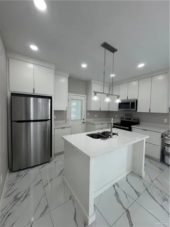 a kitchen with stainless steel appliances a refrigerator sink and microwave