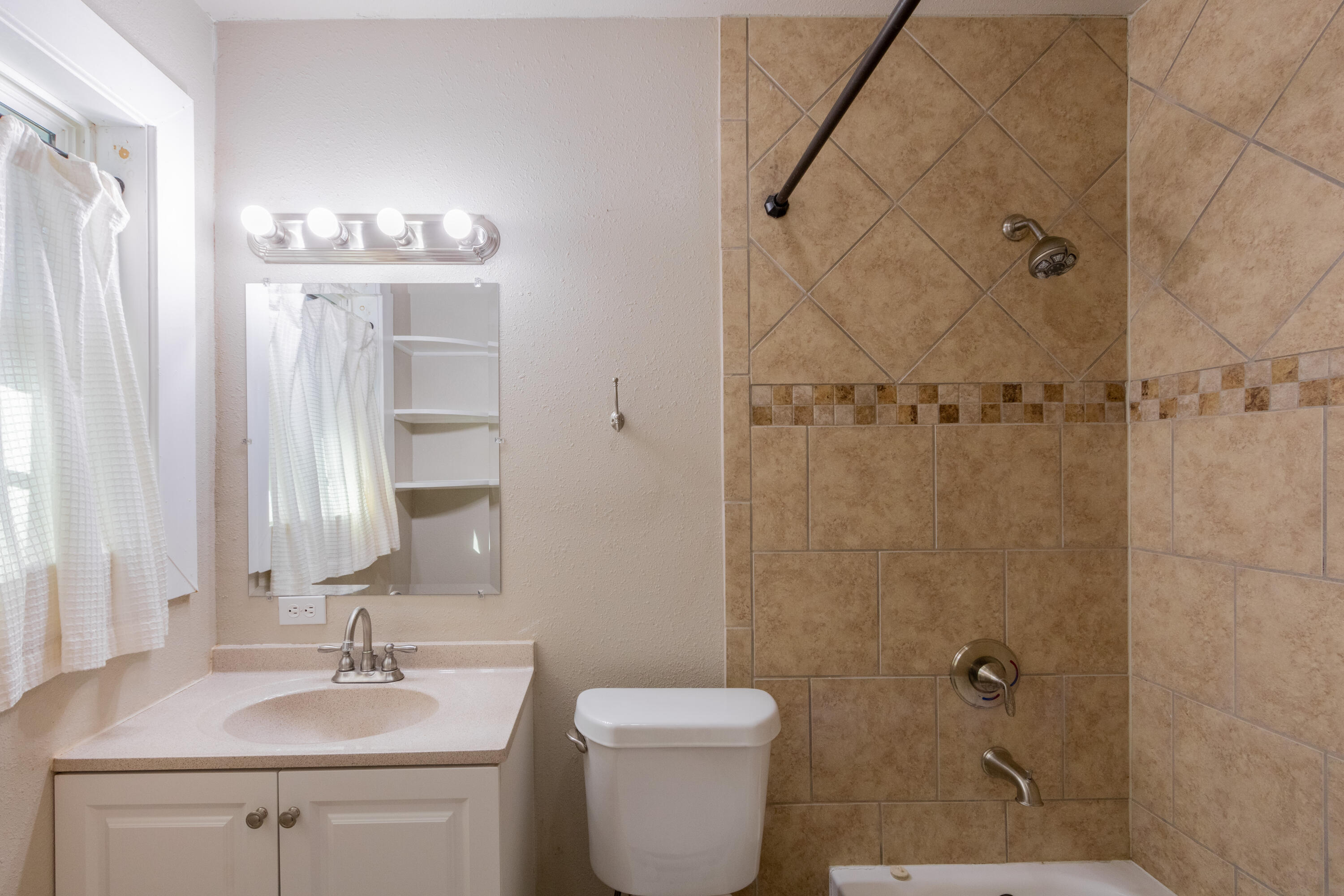 4021 38th Street Lubbock, TX 79413 - Photo 20 of 32 a bathroom with a sink a toilet and shower