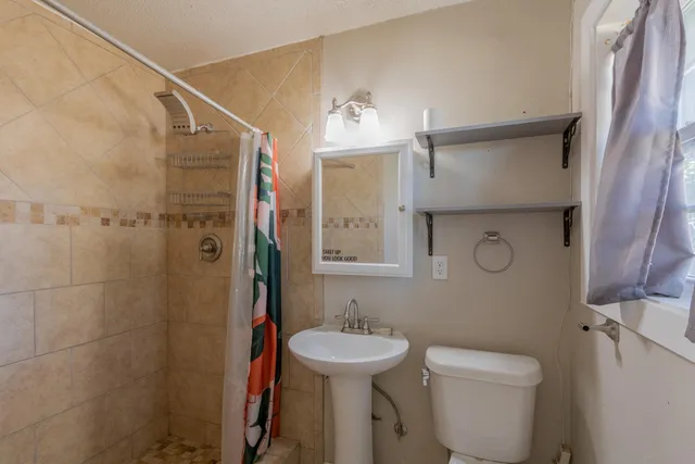 a bathroom with a toilet sink and shower