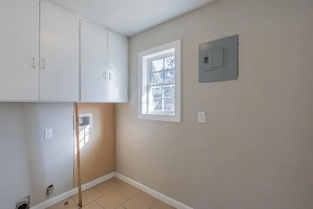 a view of an empty room with window and cabinet