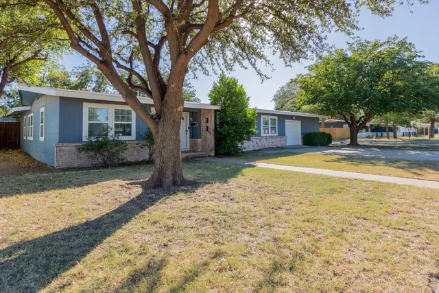 a view of a yard with a house and large tree