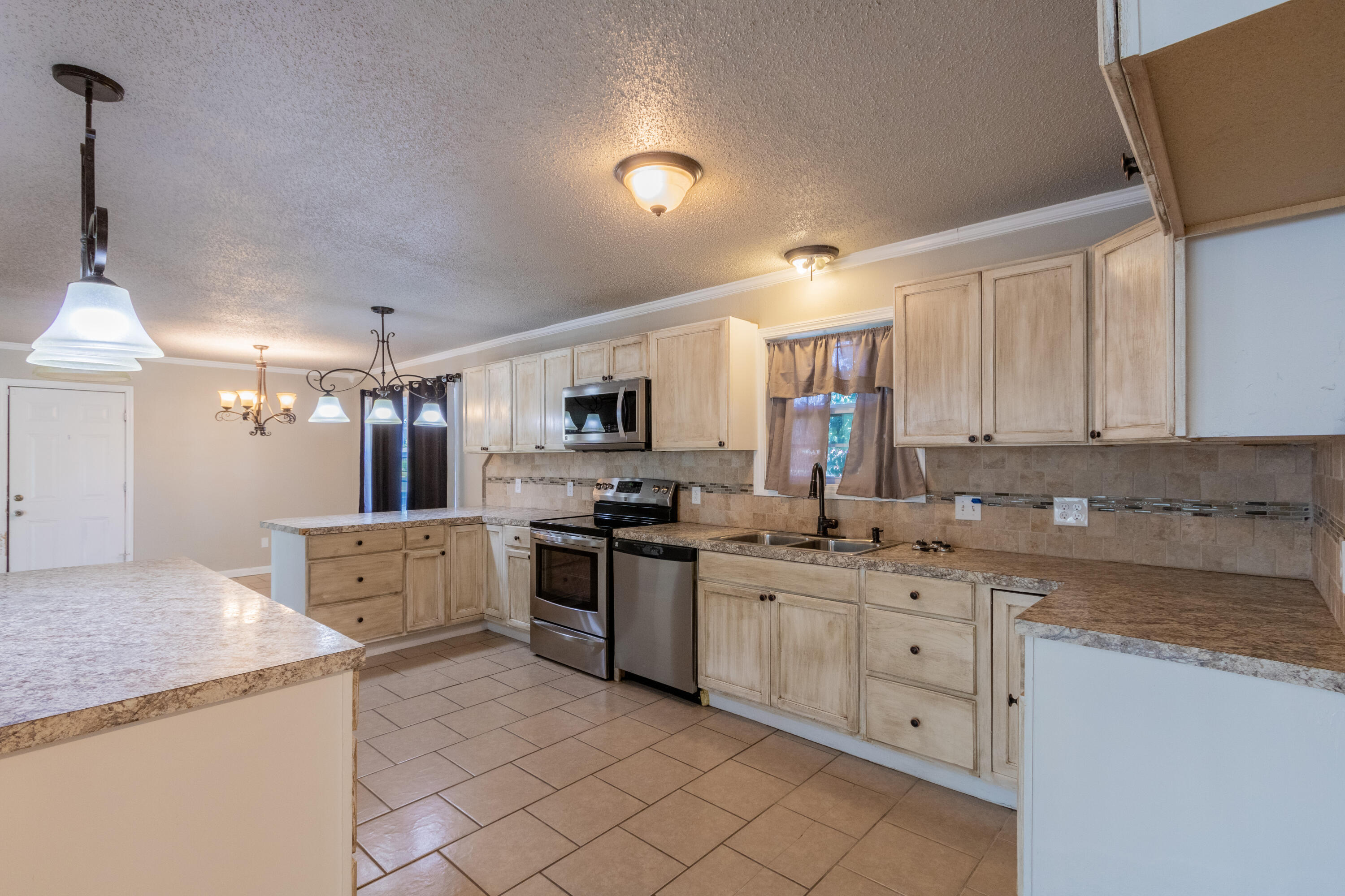 4021 38th Street Lubbock, TX 79413 - Photo 7 of 32 a kitchen with granite countertop a sink stainless steel appliances and cabinets