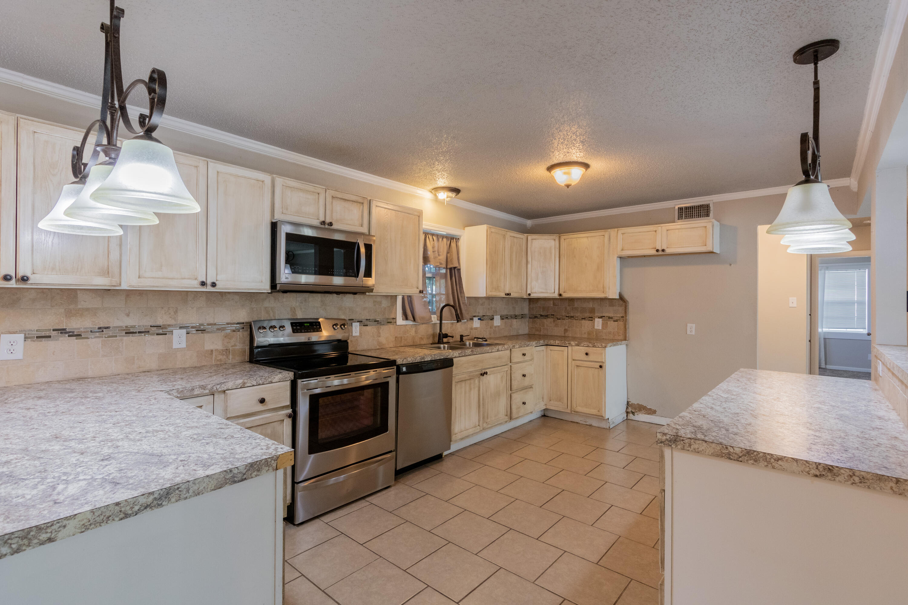 4021 38th Street Lubbock, TX 79413 - Photo 9 of 32 a kitchen with granite countertop white cabinets and white appliances
