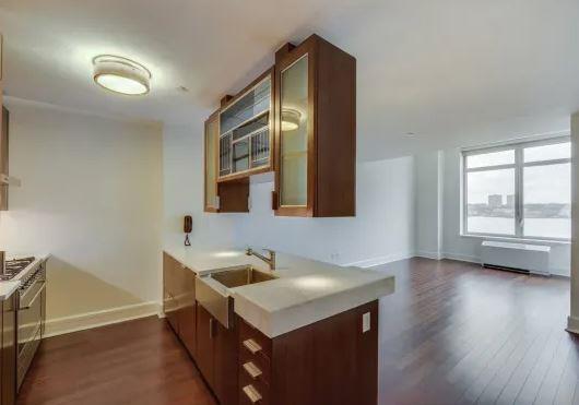 60 Riverside Boulevard, Unit 623 Manhattan, NY 10069 - Photo 2 of 12 a kitchen with a sink cabinets and wooden floor