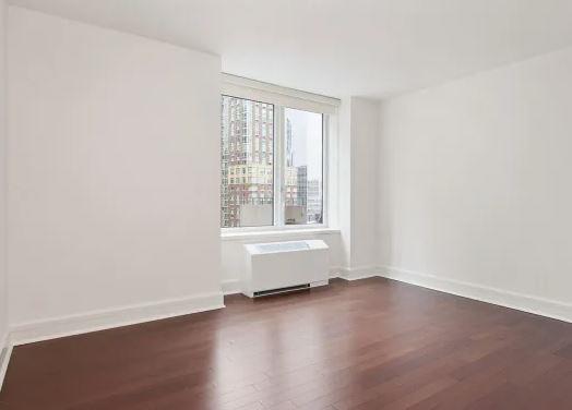 60 Riverside Boulevard, Unit 623 Manhattan, NY 10069 - Photo 4 of 12 an empty room with wooden floor and windows