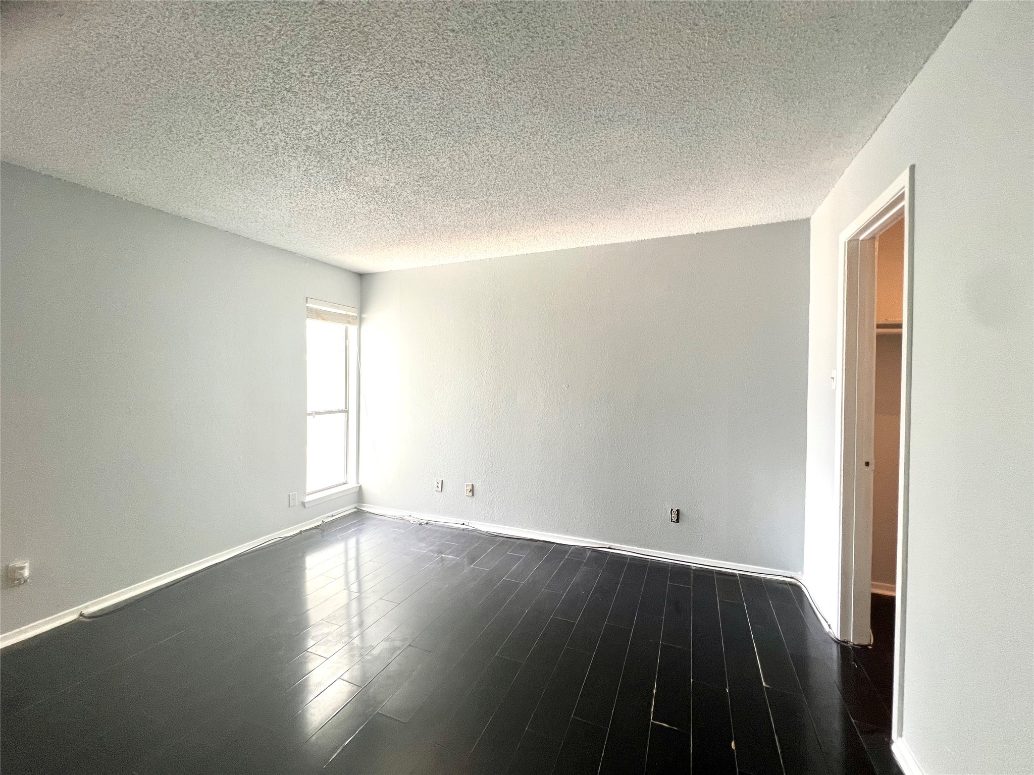 3754 Tanglewilde Street, Unit 9 Houston, TX 77063 - Photo 11 of 26 an empty room with wooden floor and windows