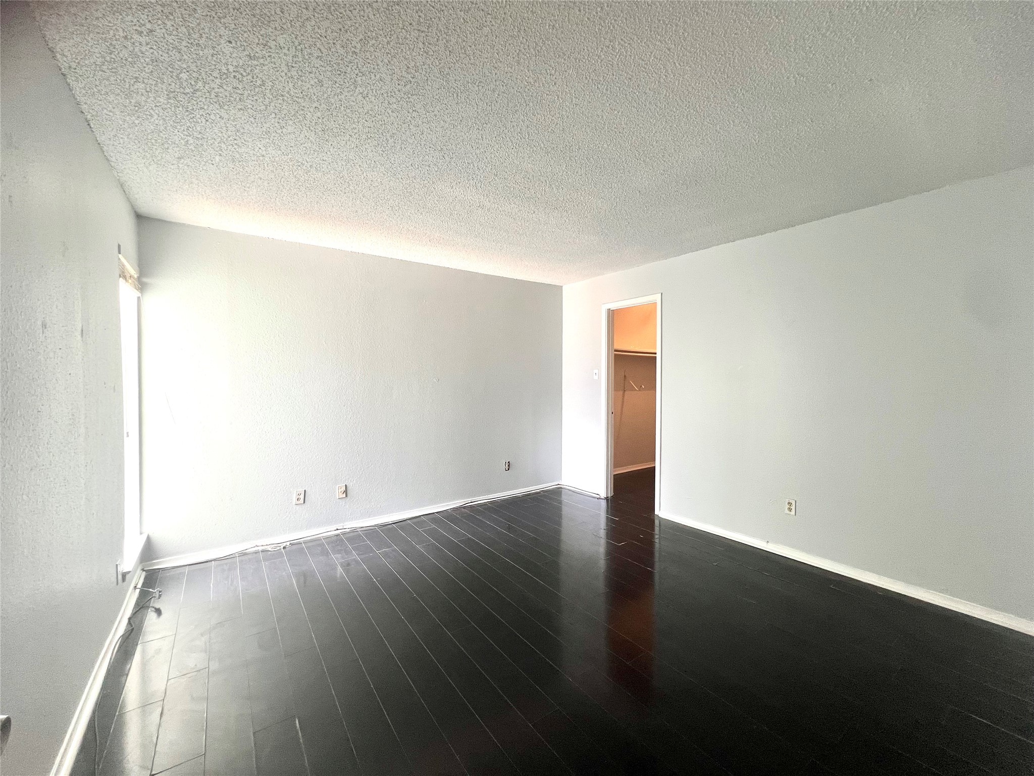 3754 Tanglewilde Street, Unit 9 Houston, TX 77063 - Photo 12 of 26 an empty room with wooden floor and windows
