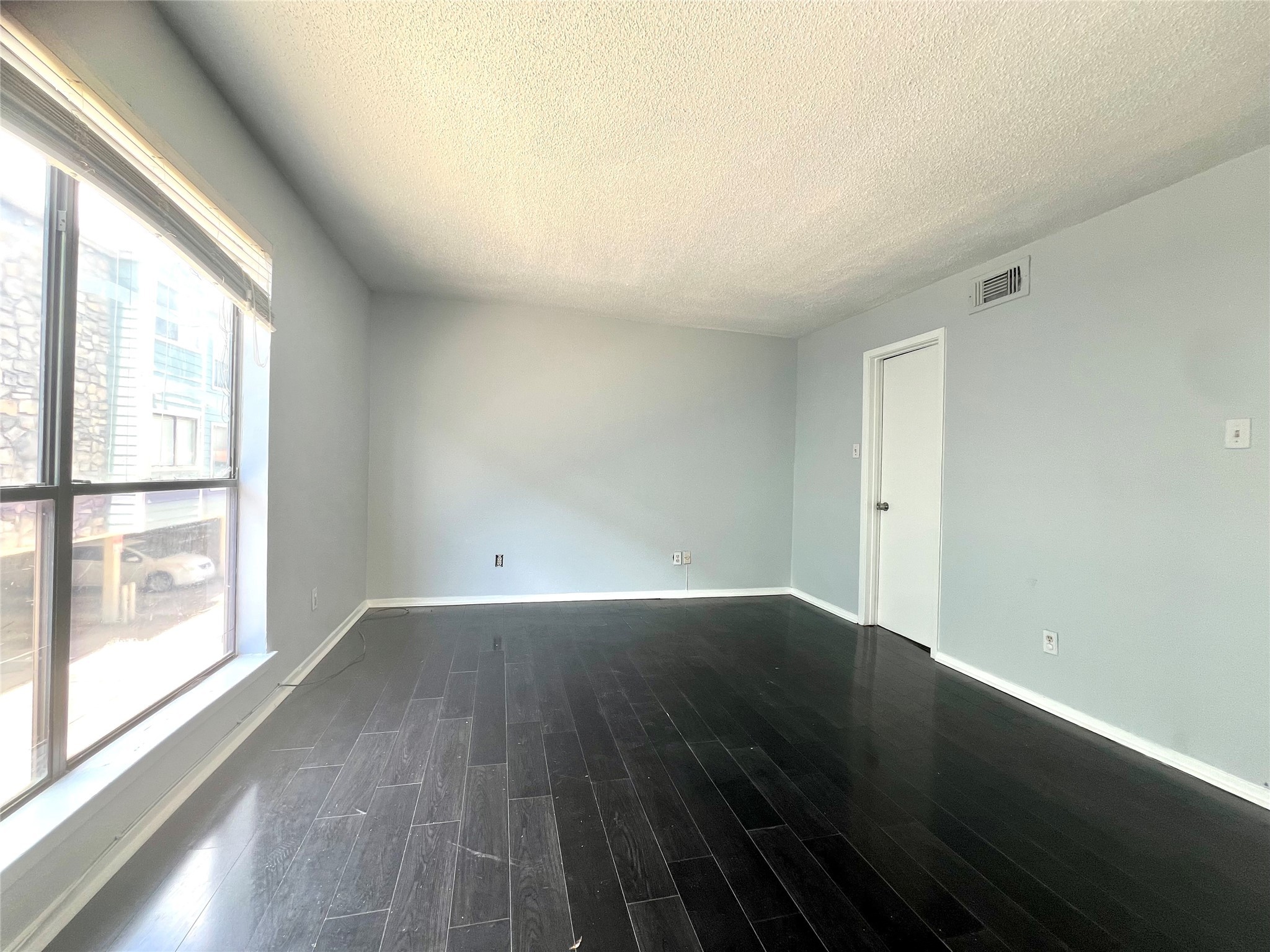 3754 Tanglewilde Street, Unit 9 Houston, TX 77063 - Photo 17 of 26 an empty room with wooden floor and windows