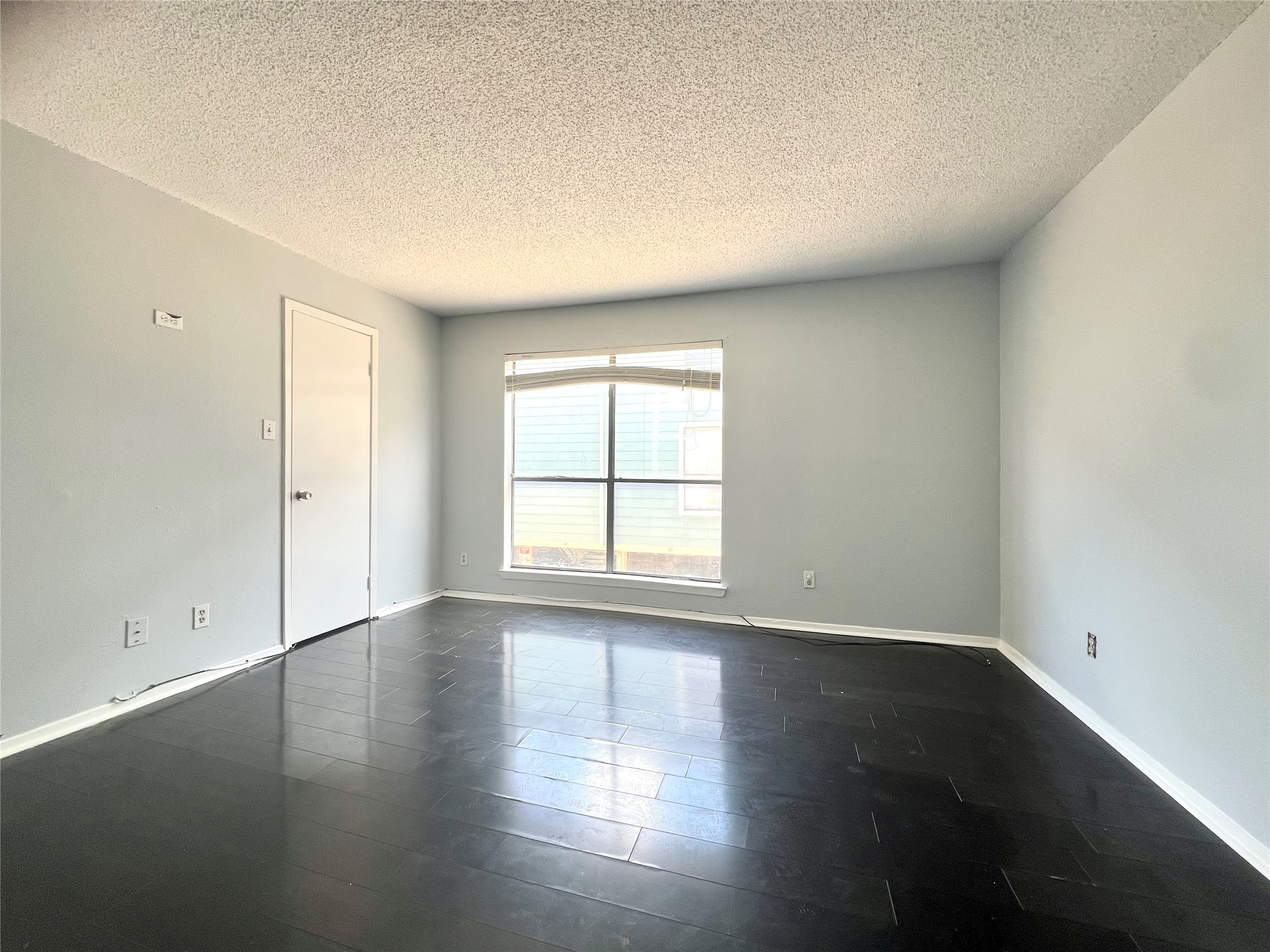 3754 Tanglewilde Street, Unit 9 Houston, TX 77063 - Photo 18 of 26 an empty room with wooden floor and windows