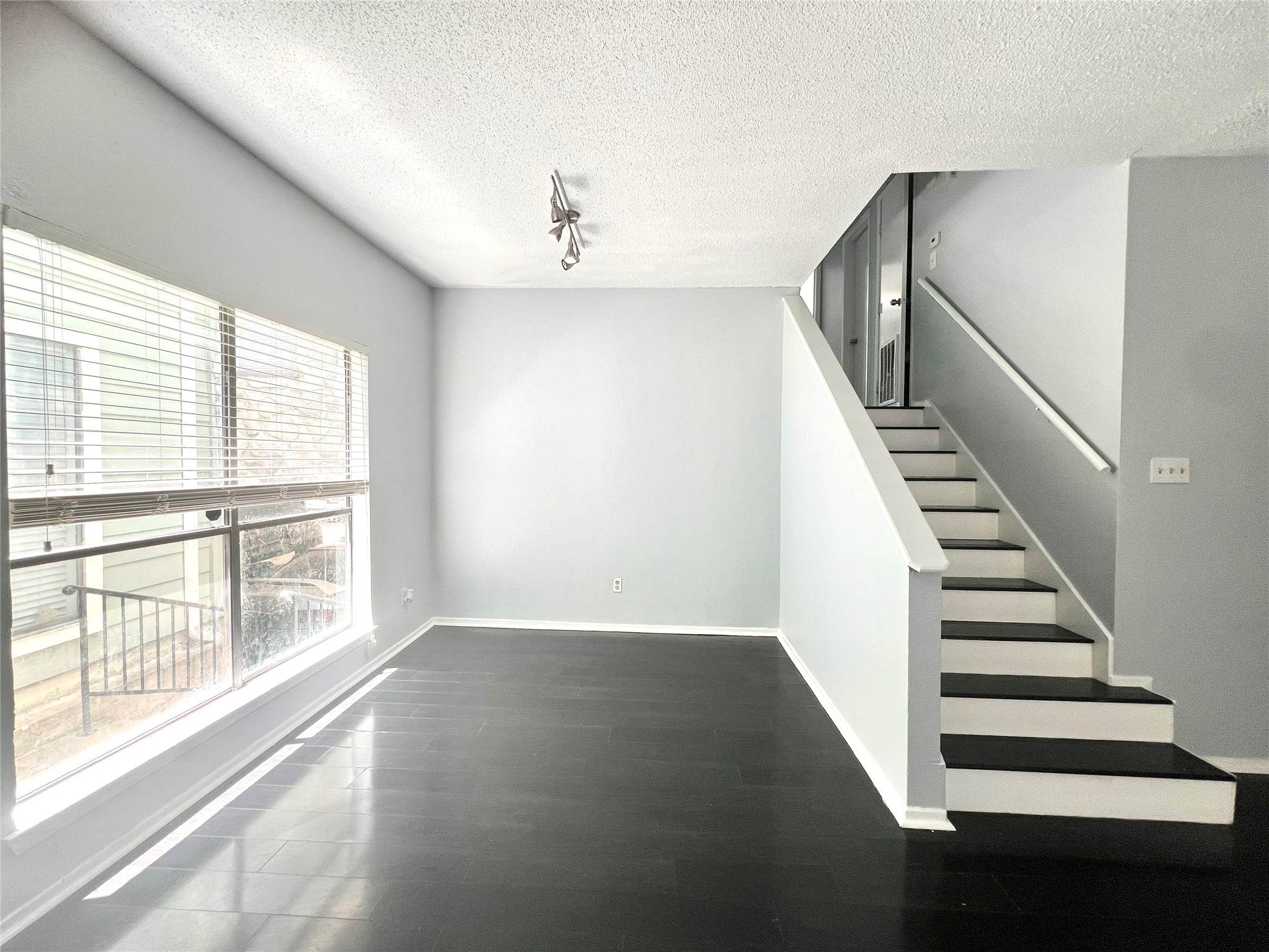 3754 Tanglewilde Street, Unit 9 Houston, TX 77063 - Photo 4 of 26 a view of an empty room with wooden floor and windows