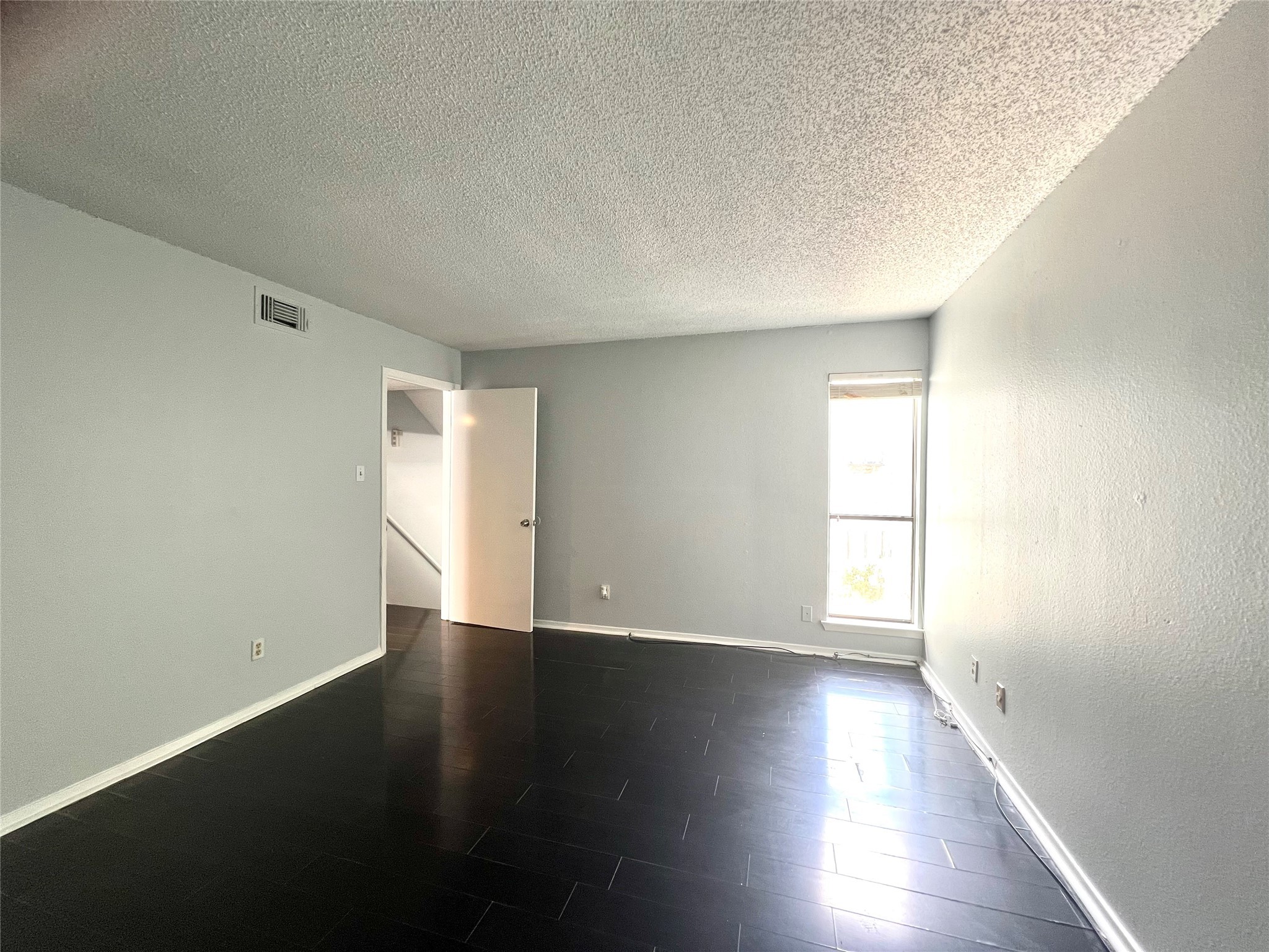 3754 Tanglewilde Street, Unit 9 Houston, TX 77063 - Photo 10 of 26 a view of an empty room with wooden floor and a window
