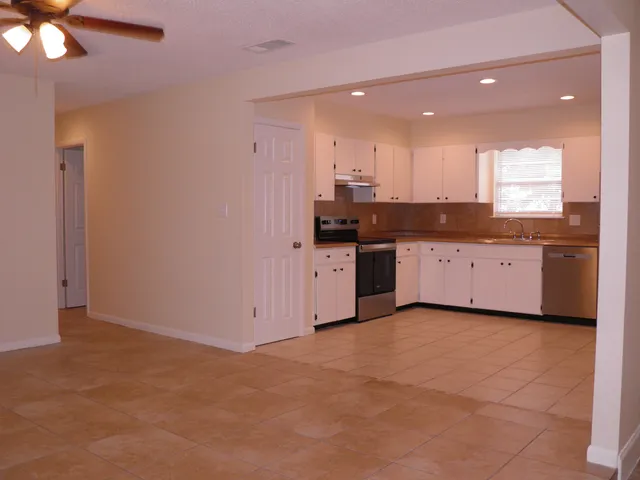 a kitchen with granite countertop a sink and cabinets