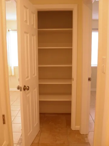 a view of walk in closet with empty racks