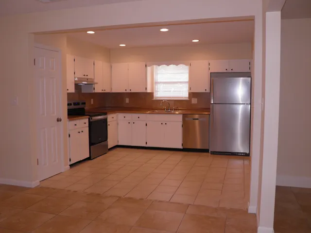 a kitchen with stainless steel appliances granite countertop a stove a sink and a refrigerator