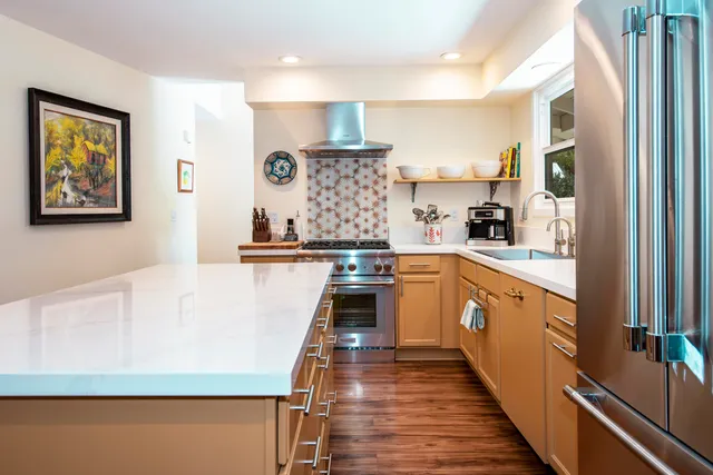 a kitchen with stainless steel appliances a stove a sink and a refrigerator