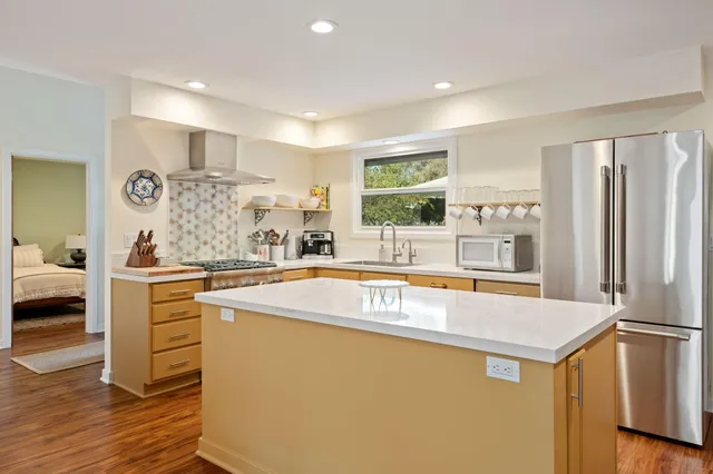 a kitchen with stainless steel appliances granite countertop a sink and a refrigerator