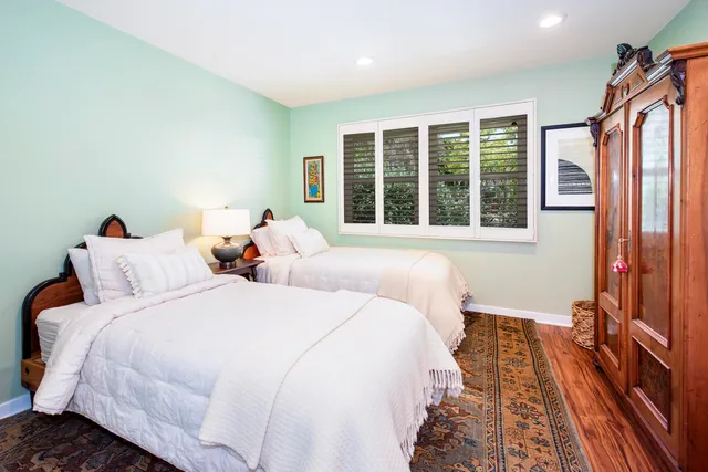 a bedroom with two beds and a large window