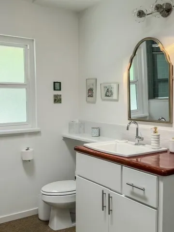 a bathroom with a toilet sink and mirror