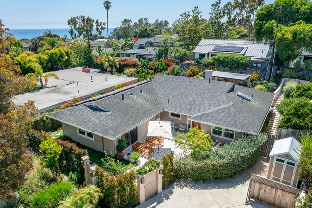 an aerial view of a house with garden space and street view