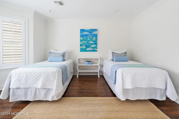 a bedroom with a bed and a wooden floor