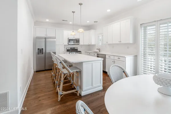 a kitchen with stainless steel appliances a white refrigerator a stove a sink and a microwave