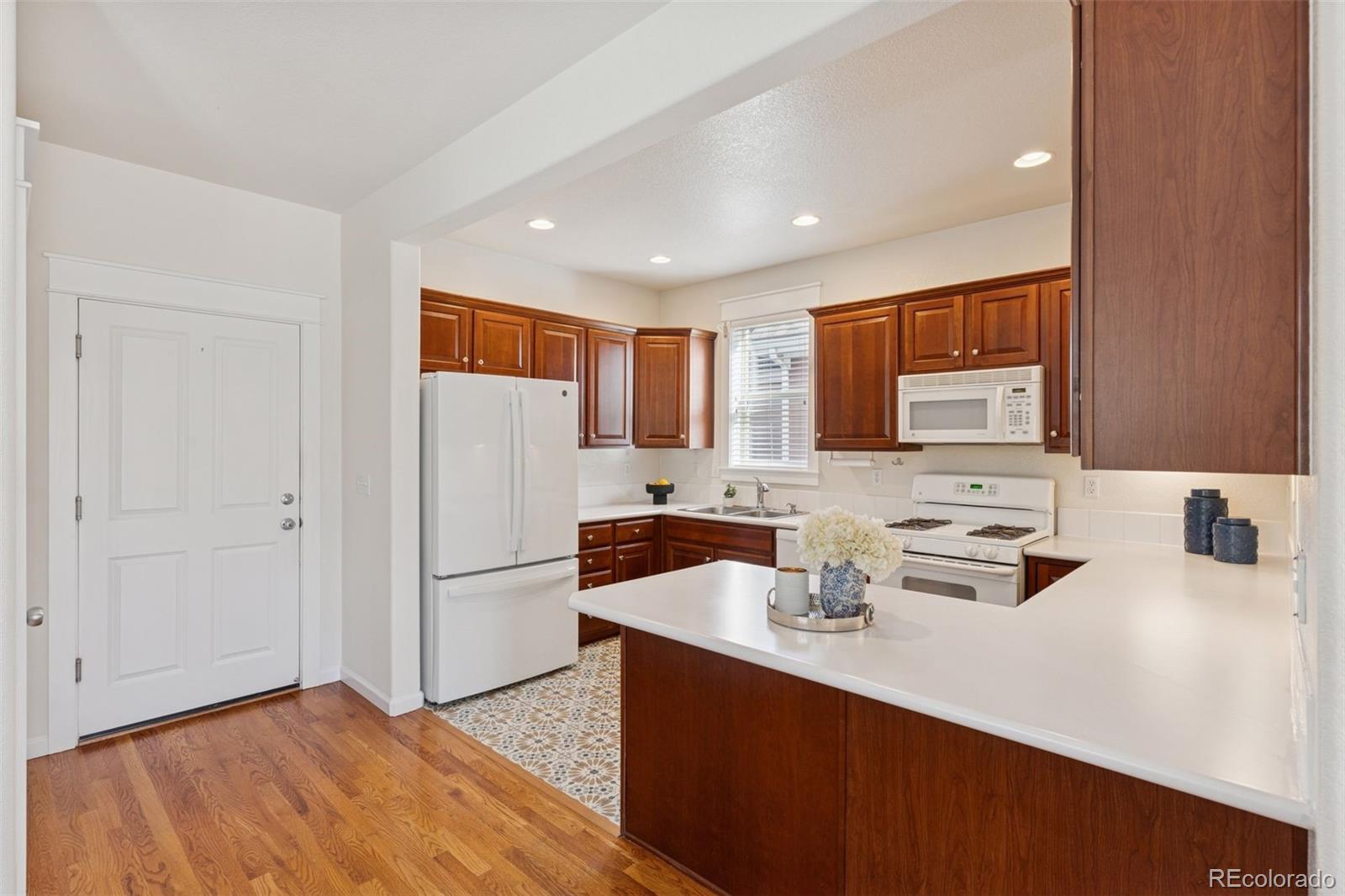 2872 Alton Street Denver, CO 80238 - Photo 12 of 46 a kitchen with stainless steel appliances a refrigerator sink and white cabinets