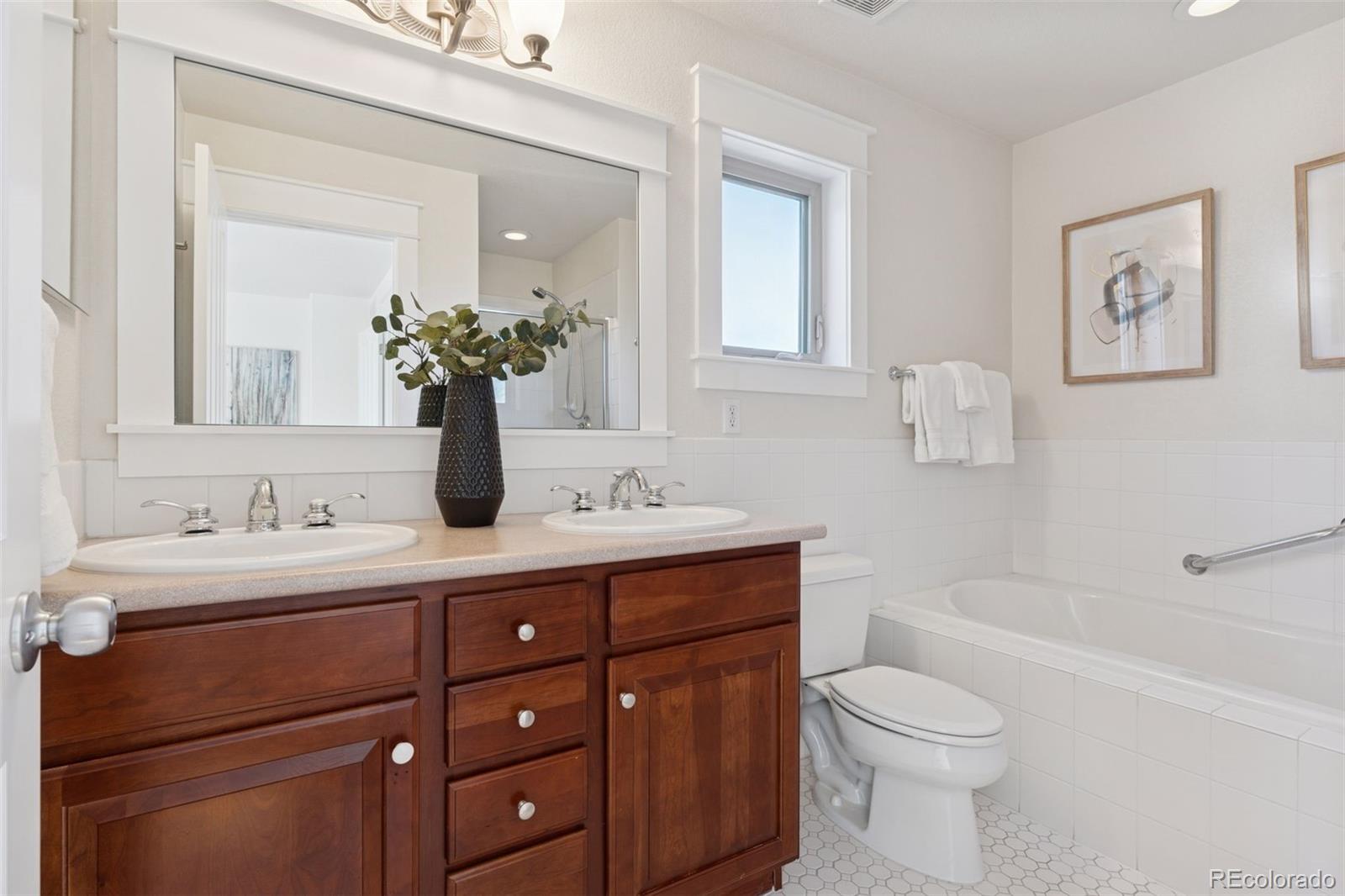 2872 Alton Street Denver, CO 80238 - Photo 21 of 46 a bathroom with a toilet a sink a tub and mirror