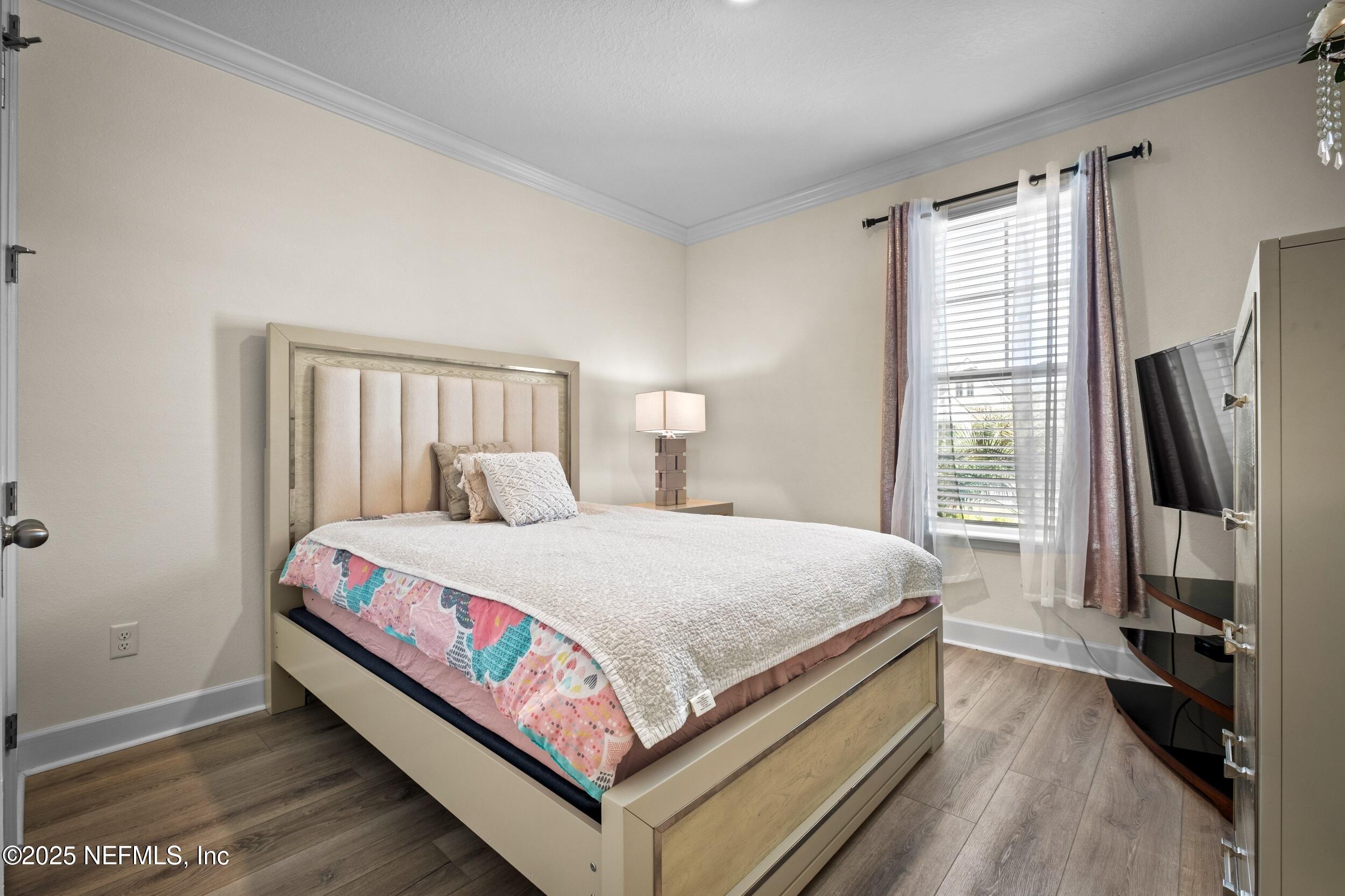 80 Widener Court St. Johns, FL 32259 - Photo 16 of 60 a bed room with a bed and a flat tv screen on a dresser