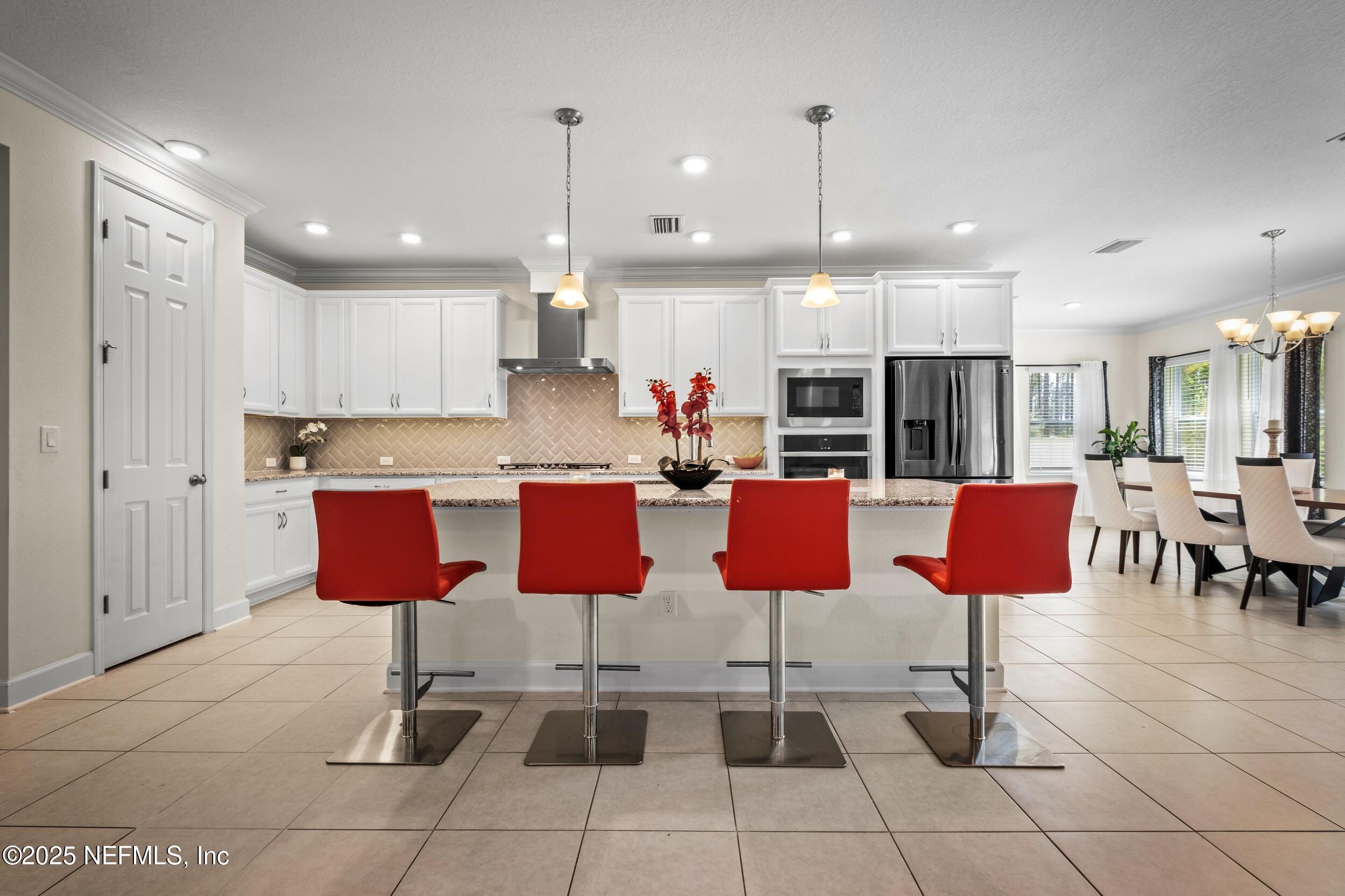 80 Widener Court St. Johns, FL 32259 - Photo 31 of 60 a kitchen with stainless steel appliances kitchen island granite countertop a table and chairs