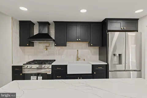 a kitchen with stainless steel appliances a sink a stove a refrigerator and cabinets