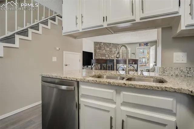 a kitchen with stainless steel appliances granite countertop a sink and cabinets