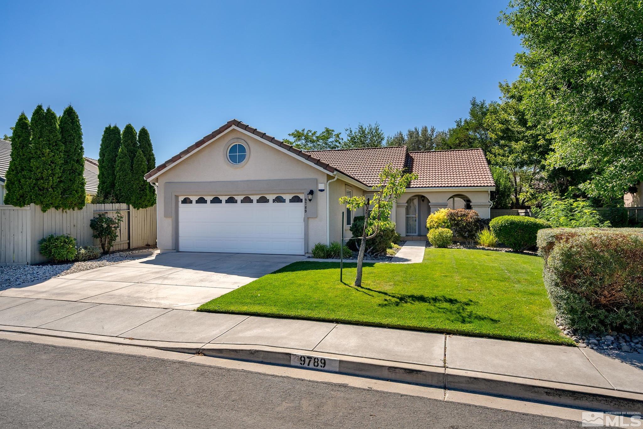 9789 Thunder Mountain Way Reno, NV 89521 - Photo 1 of 17 a front view of a house with a yard and garage