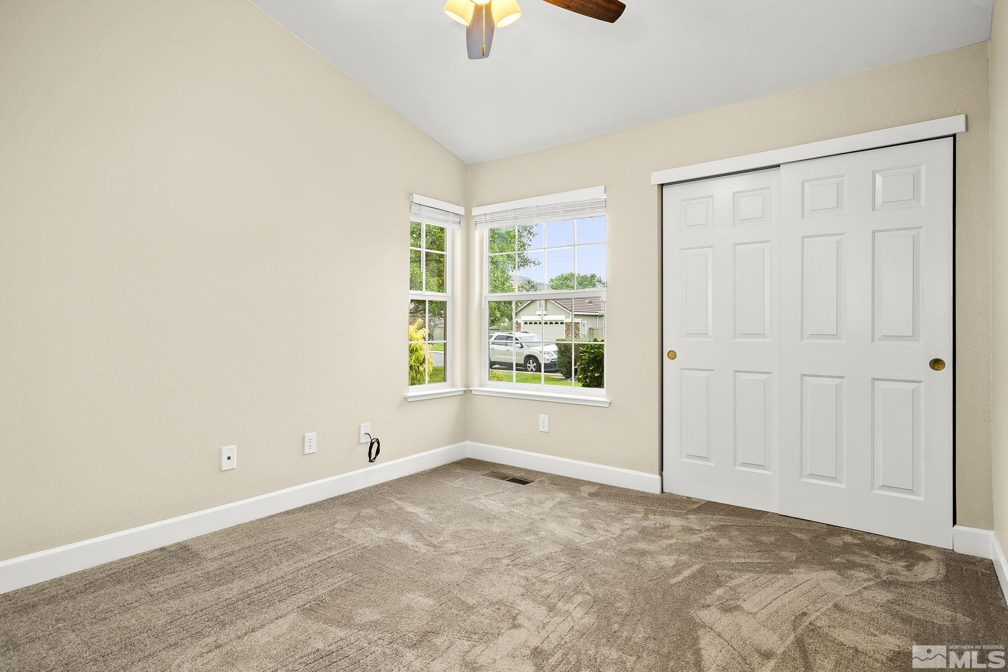 9789 Thunder Mountain Way Reno, NV 89521 - Photo 12 of 17 a view of an empty room with window and a chandelier fan