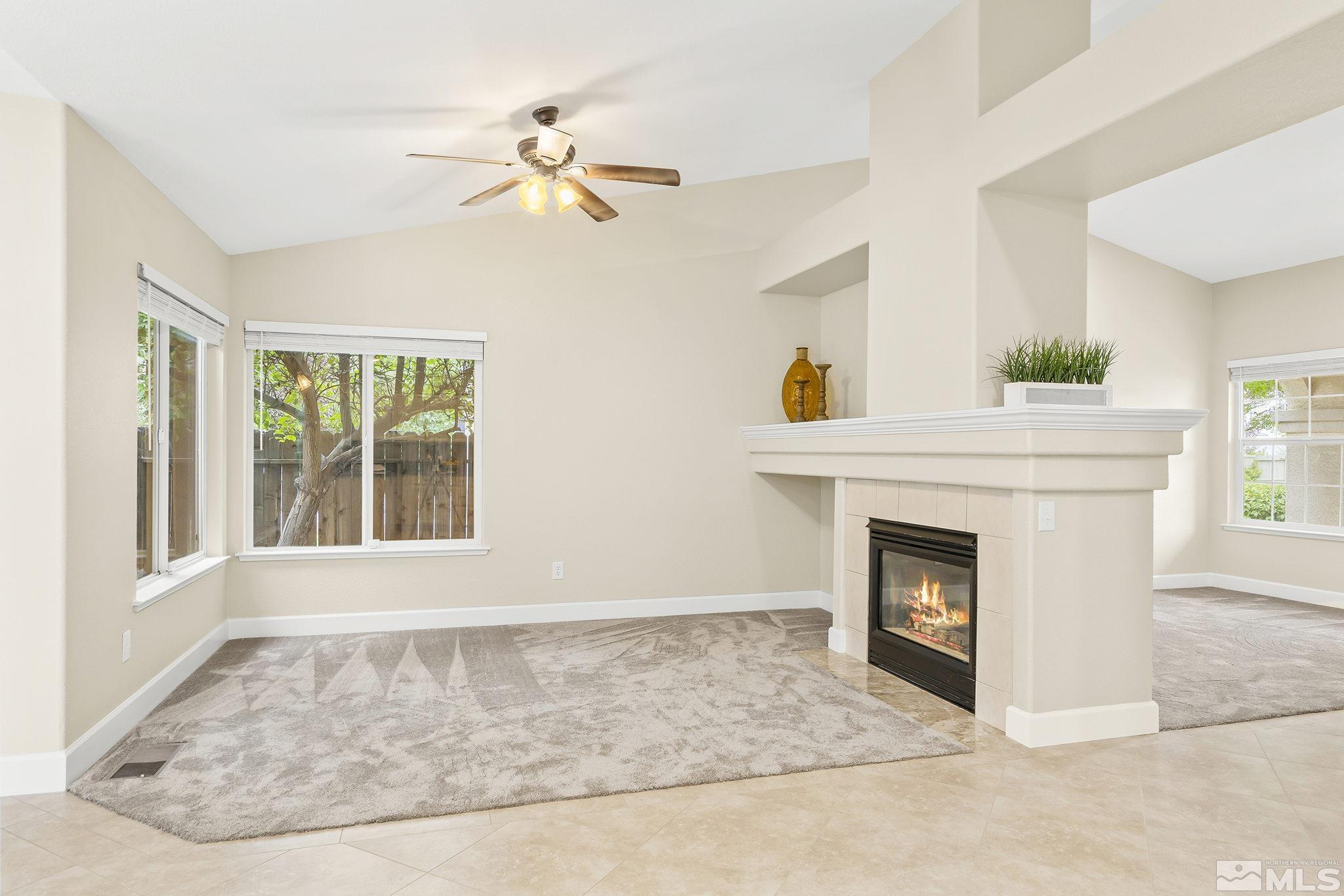 9789 Thunder Mountain Way Reno, NV 89521 - Photo 2 of 17 a view of an empty room with a fireplace and a window