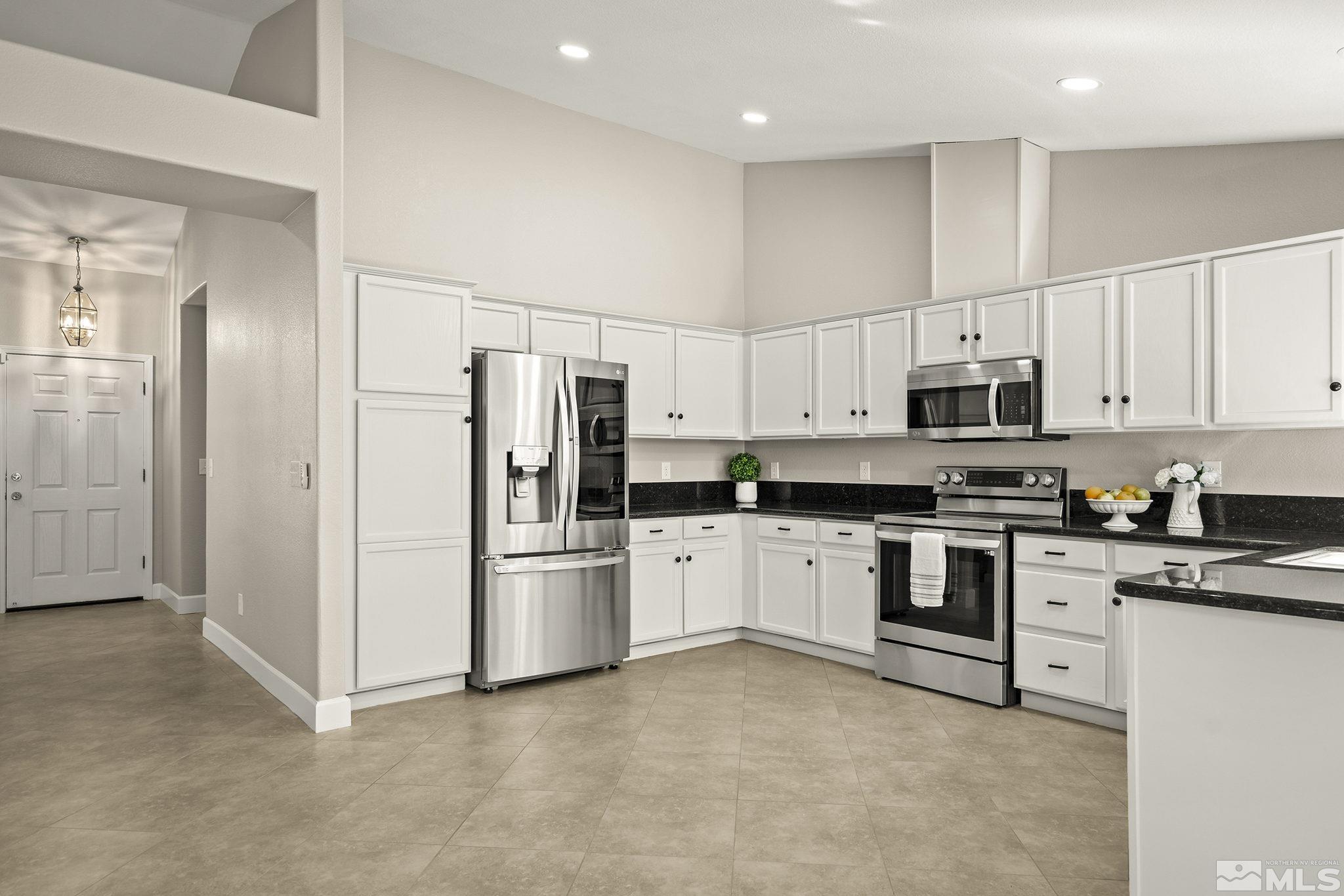9789 Thunder Mountain Way Reno, NV 89521 - Photo 4 of 17 a kitchen with cabinets and stainless steel appliances
