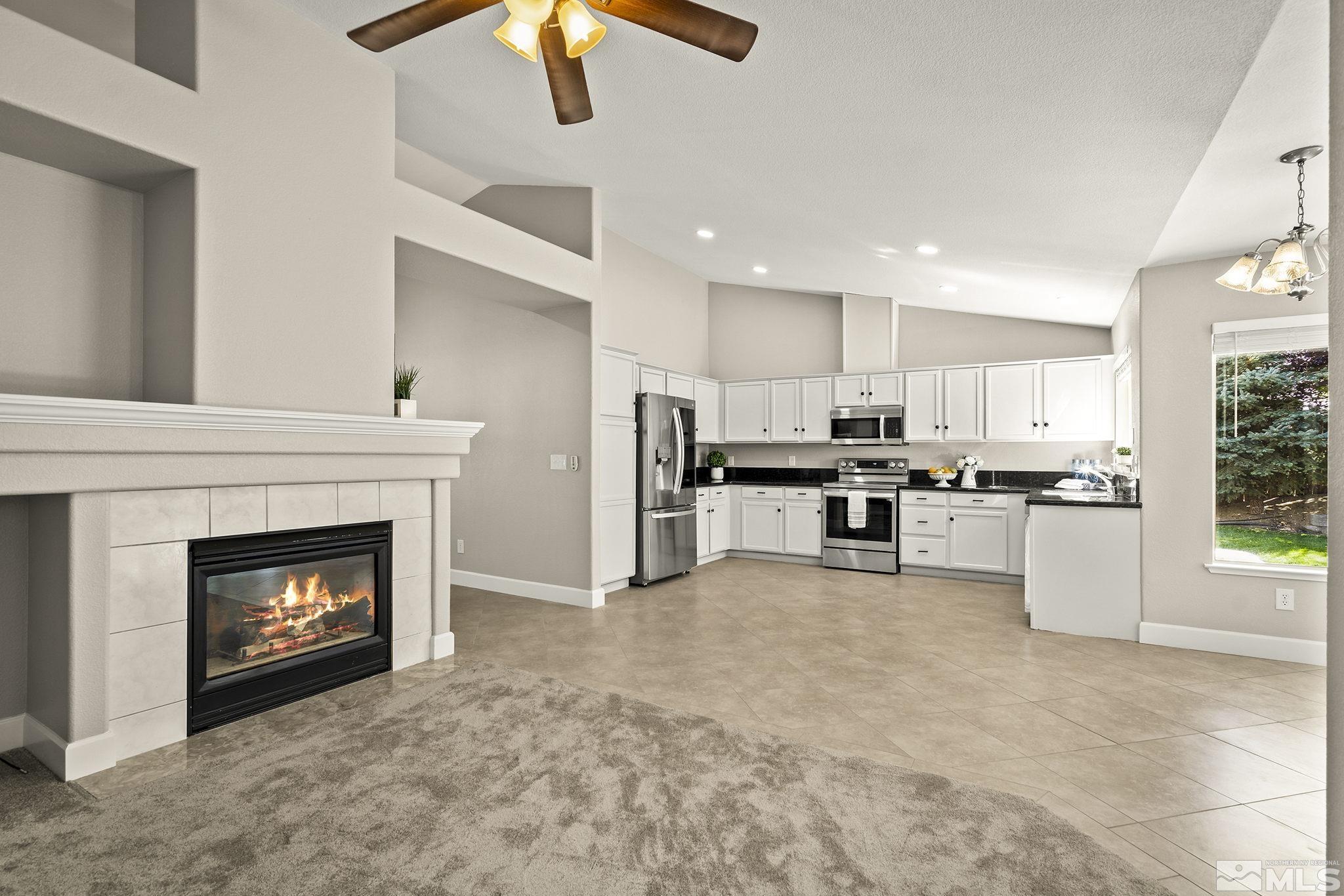 9789 Thunder Mountain Way Reno, NV 89521 - Photo 5 of 17 a open kitchen view with fireplace cabinets and white appliances