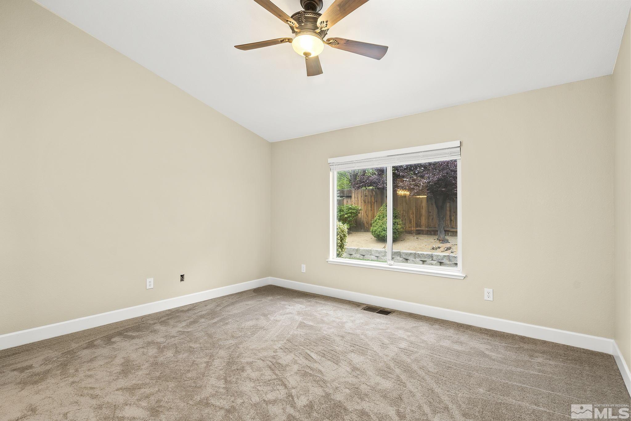 9789 Thunder Mountain Way Reno, NV 89521 - Photo 8 of 17 an empty room with a window and a fan