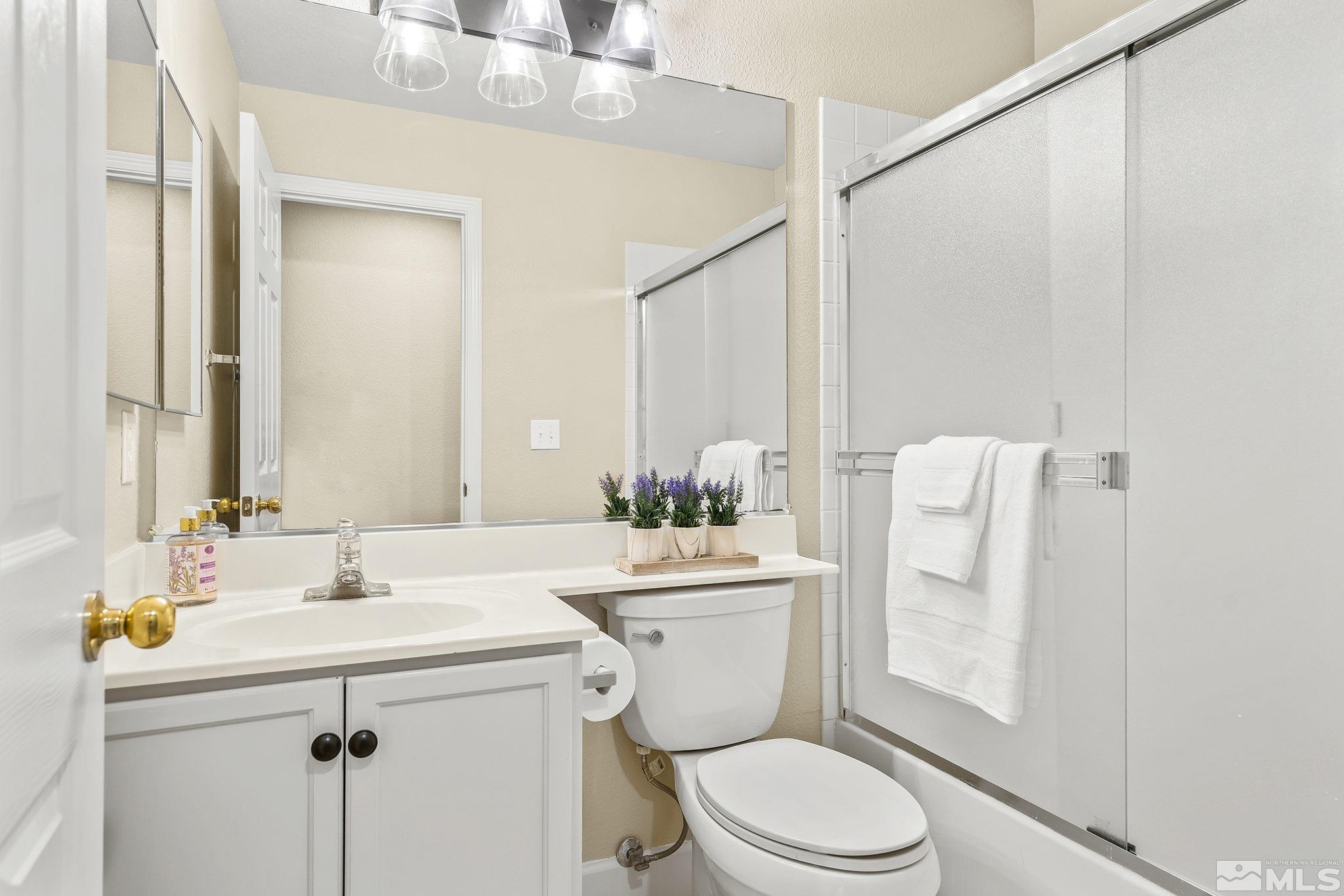 9789 Thunder Mountain Way Reno, NV 89521 - Photo 9 of 17 a bathroom with a sink mirror vanity and toilet