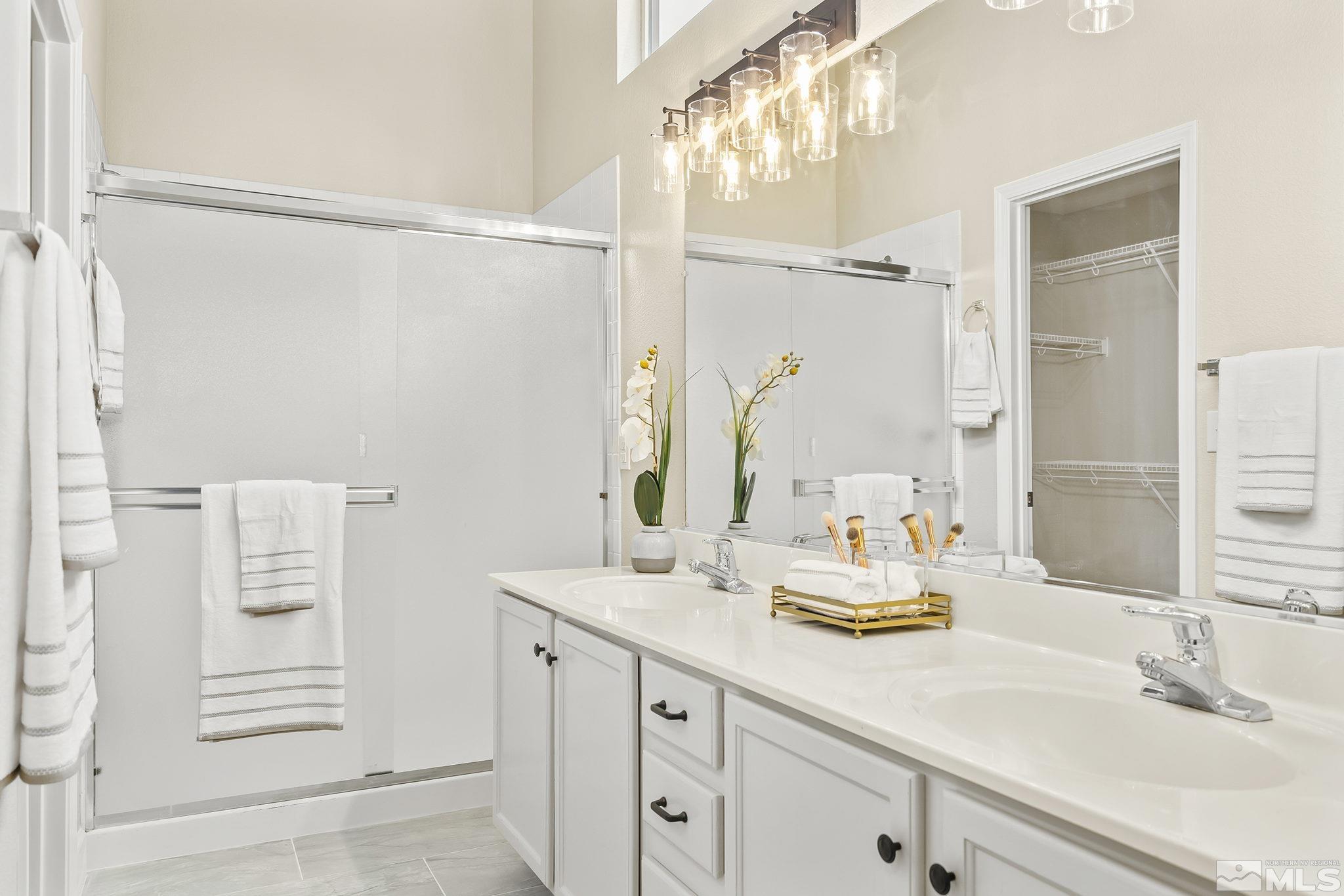 9789 Thunder Mountain Way Reno, NV 89521 - Photo 10 of 17 a bathroom with a double vanity sink and a mirror