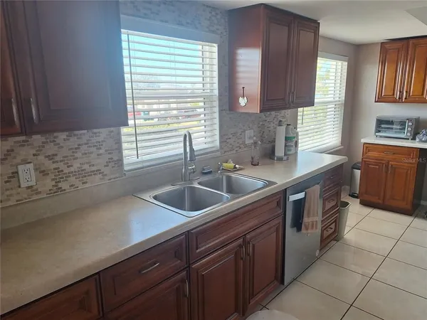 a kitchen with stainless steel appliances sink a window and cabinets