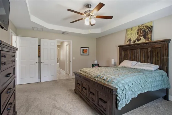 a spacious bedroom with a bed and a chandelier