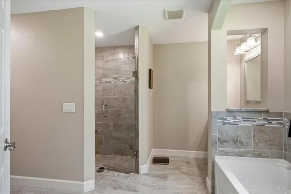a bathroom with a granite countertop bathtub shower and sink