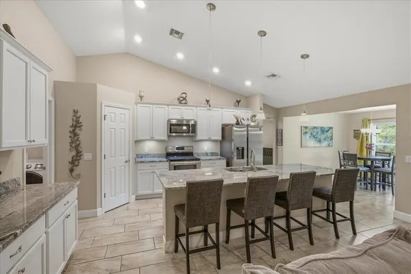 a large kitchen with a table and chairs