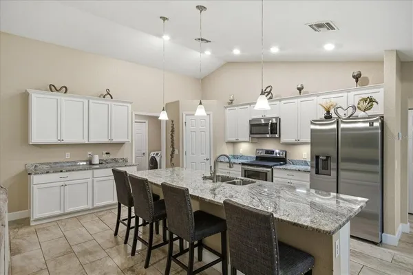 a kitchen with stainless steel appliances kitchen island granite countertop a sink and cabinets