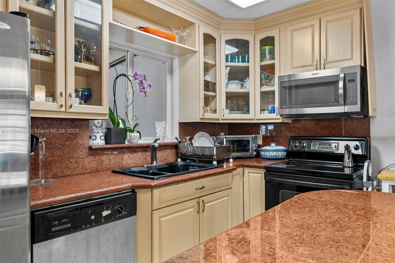 5810 Southwest 22nd Street Miami, FL 33155 - Photo 13 of 54 a kitchen with stainless steel appliances granite countertop a stove and cabinets