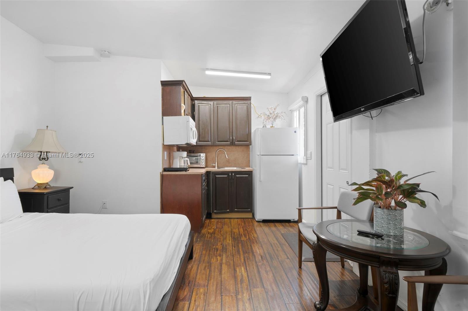 5810 Southwest 22nd Street Miami, FL 33155 - Photo 23 of 54 a kitchen with a table chairs refrigerator and microwave