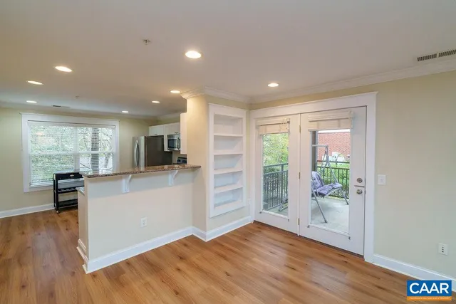 a open kitchen with white cabinets and wooden floor
