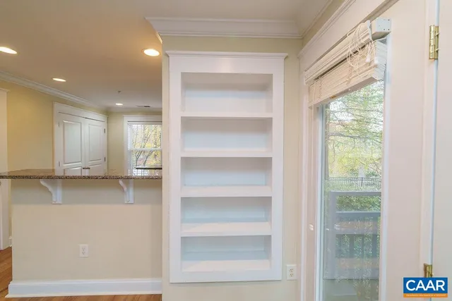 a view of a kitchen with white cabinets and a window
