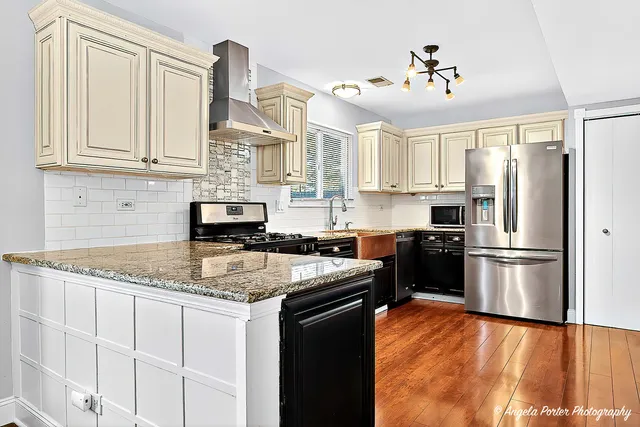 a view of a livingroom with wooden floor a ceiling fan and a window