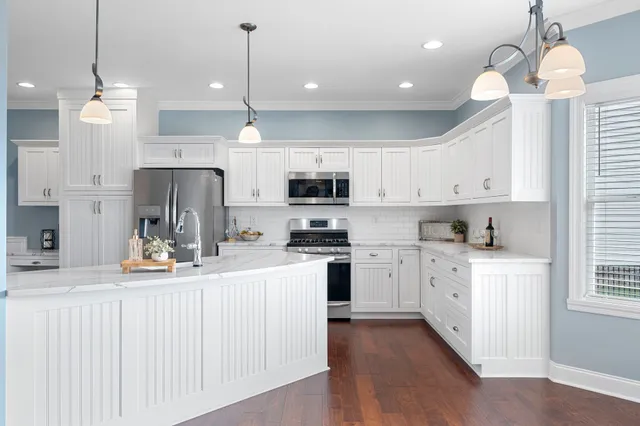 a kitchen with white cabinets and stainless steel appliances